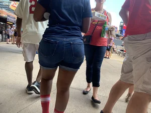Bunch of girls in various outfits at a Cardinals baseball game
