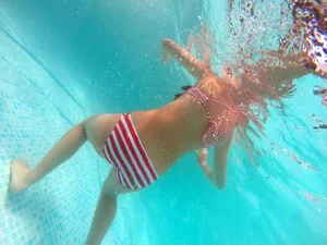 A hot teen neighbor in striped bikini underwater showing pubes