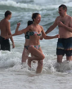 Cute skinny girl in a bikini at the beach playing in the water