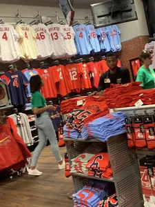 Bunch of girls in various outfits at a Cardinals baseball game