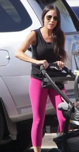 Milf brunette in purplish-pink leggings looking sexy in the parking lot
