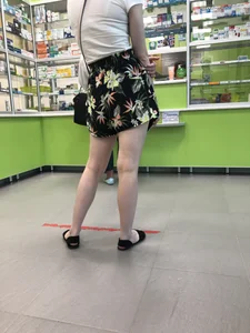 Blonde with Pale Skin in a Skirt and Sandals in the Pharmacy - Hot Legs Closeup