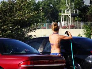 Group of cute girls at a car wash in bikinis and shorts