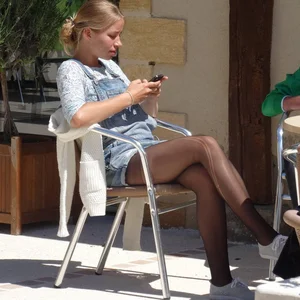 Girl in Torn Black Pantyhose Sitting with Her Legs Crossed Candid