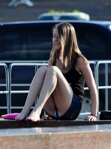 Barefoot Girl in a Denim Skirt On a City Fountain Flashing Her Panties
