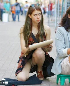 Girl in a Dress Standing on One Knee on the Street Flashing Her Panties