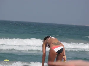 Skinny and sexy lady in a bikini playing on the beach