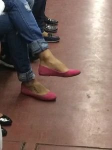 Feet of a Young Subway Girl in Pink Flats in a Subway Train, Sitting With Crossed Legs