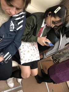 Closeups of a subway candid teen's legs, she's wearing a skirt and black knee socks