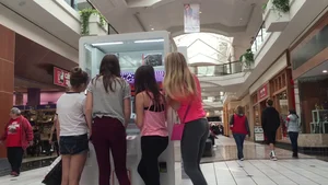 Little blonde teen in grey leggings at the mall with her friends