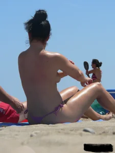 Purple thong topless lady on the beach gets oiled up by her husband