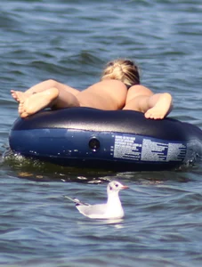 Black thong bikini blonde with a nice ass out on a tube in the water