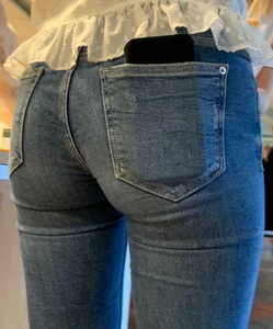 Perfect tight butt in blue jeans, candid girl wearing a blouse