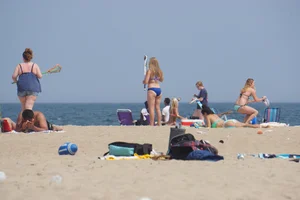 Cute girls in light blue and purple bikinis on the beach