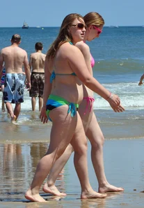 Two beach friends in bikinis one with back dimples and the other thick