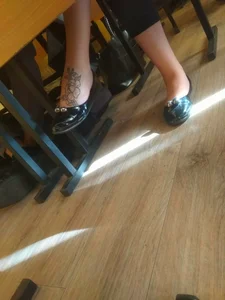 Feet in Pantyhose and Flats Under Desk in College Classroom Closeup