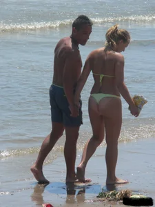 Sexy blonde on the beach in a yellow thong bikini