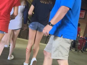 Bunch of girls in various outfits at a Cardinals baseball game