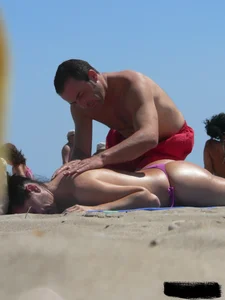 Purple thong topless lady on the beach gets oiled up by her husband
