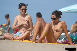 2 topless girls at the beach in thongs