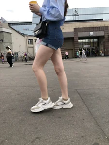 Candid Girl in Blue Denim Shorts and Sneakers Walking Down the Street - Hot Legs Crepshots Collection