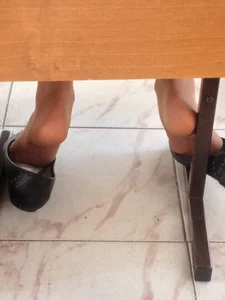 Under Desk Feet Closeups of a College Teen With Her Shoes Half Taken Off