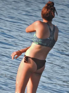 Sexy beach girl in a Nike sports bra and black bikini bottom