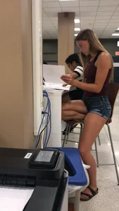 Cute teen wearing denim shorts sitting on a bar stool