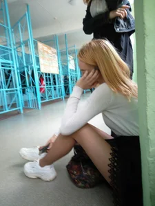 Skinny Blonde in a Skirt and Blouse Sitting on the Floor Candid Photo