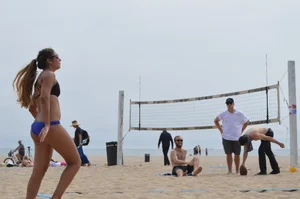 Sexy beach volleyball girl in sport bra top with pokies and blue bikini bottom