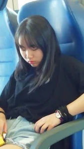 Two cute Asian teens on the bus in shorts showing their legs