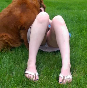Candid girl lying on the grass in a park with her dog accidental upskirt