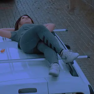 Chunky girl in yoga pants chilling on the roof of her car
