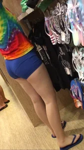 Girl in Spandex Mini Shorts and a Colorful T-Shirt at the Store Candid Photos
