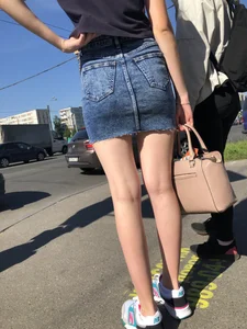 Cute Girl in a Short Denim Skirt Walking on a Street And Waiting on a Crosswalk Gallery