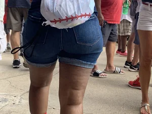 Bunch of girls in various outfits at a Cardinals baseball game