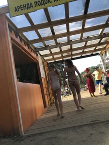 Young Skinny Girl Taking Off Her Denim Shorts Leaving a Swimsuit - Bending Over While Laying a Blanket on the Ground at a Lake Nature Park Gallery