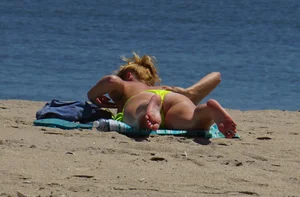 Sexy ass blonde milf on the beach in a thong with cameltoe and bending over