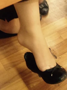 Teen college girl's feet closeup in classroom: dangle flats