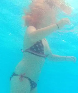Underwater shots of a bikini teen swimming in the pool