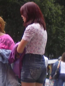 Redhead girl with her cheeks eating her denim shorts