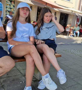Candid Teens in Shorts And Sneakers Sitting on the Street Bench