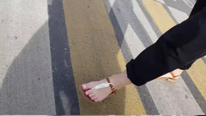 Feet in Sandals Closeup on a Crosswalk