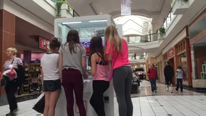 Little blonde teen in grey leggings at the mall with her friends