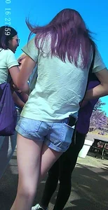 Skinny girl with purple hair in denim shorts