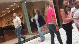 Little blonde teen in grey leggings at the mall with her friends