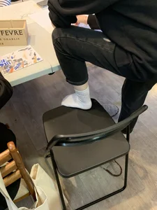 Young Skinny Girl's Legs in Black Jeans And White Socks Foot on the Chair Closeup