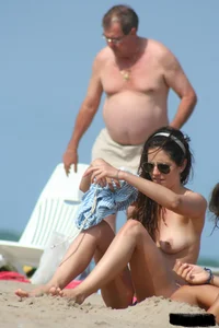 2 topless girls at the beach in thongs