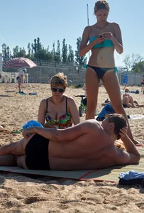 Sexy blonde milf on the beach in blue thong bikini and showing nice camel toe