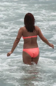 Thick girl in orange bikini playing on the beach